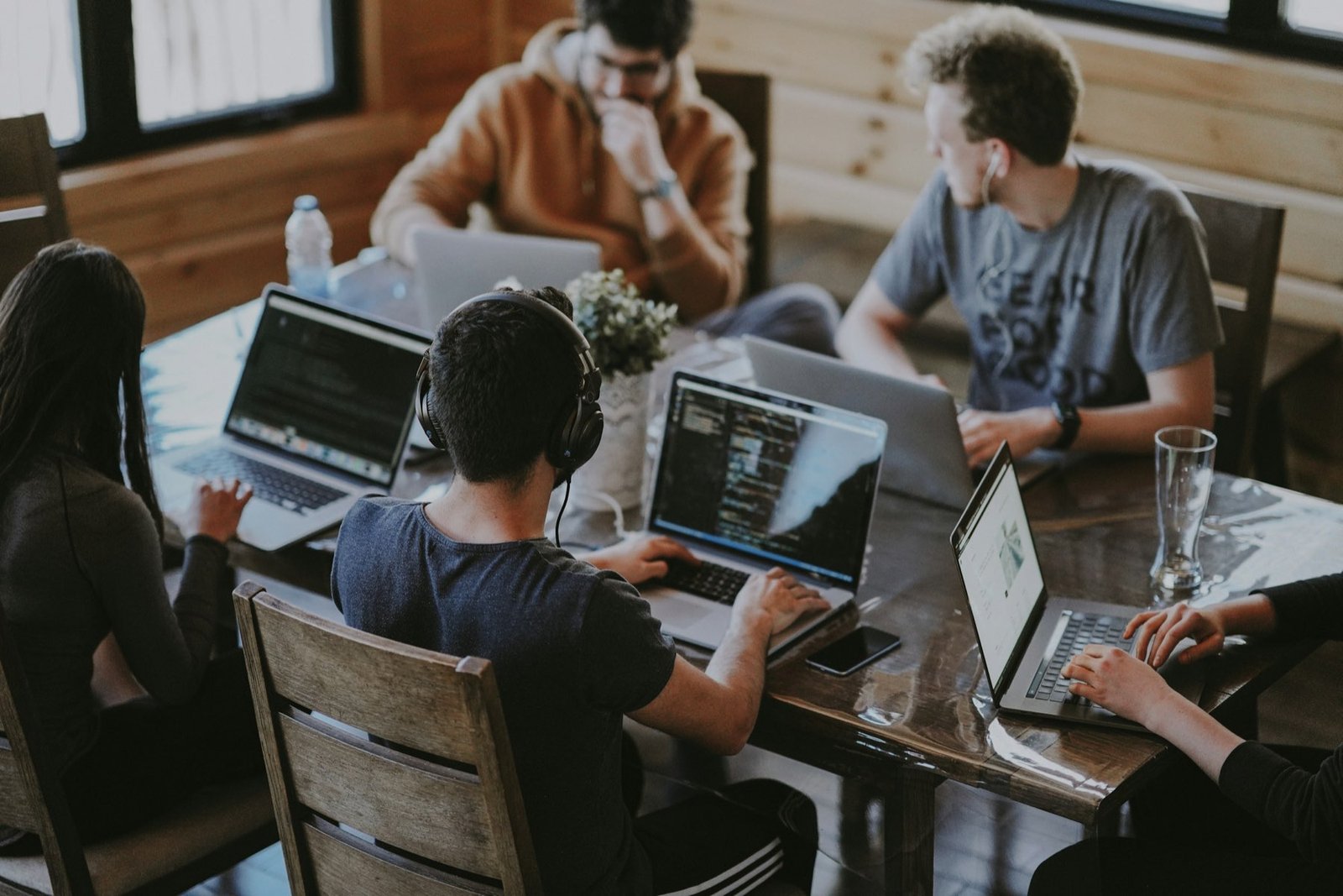 Marketing team planning a campaign around a table with laptops
